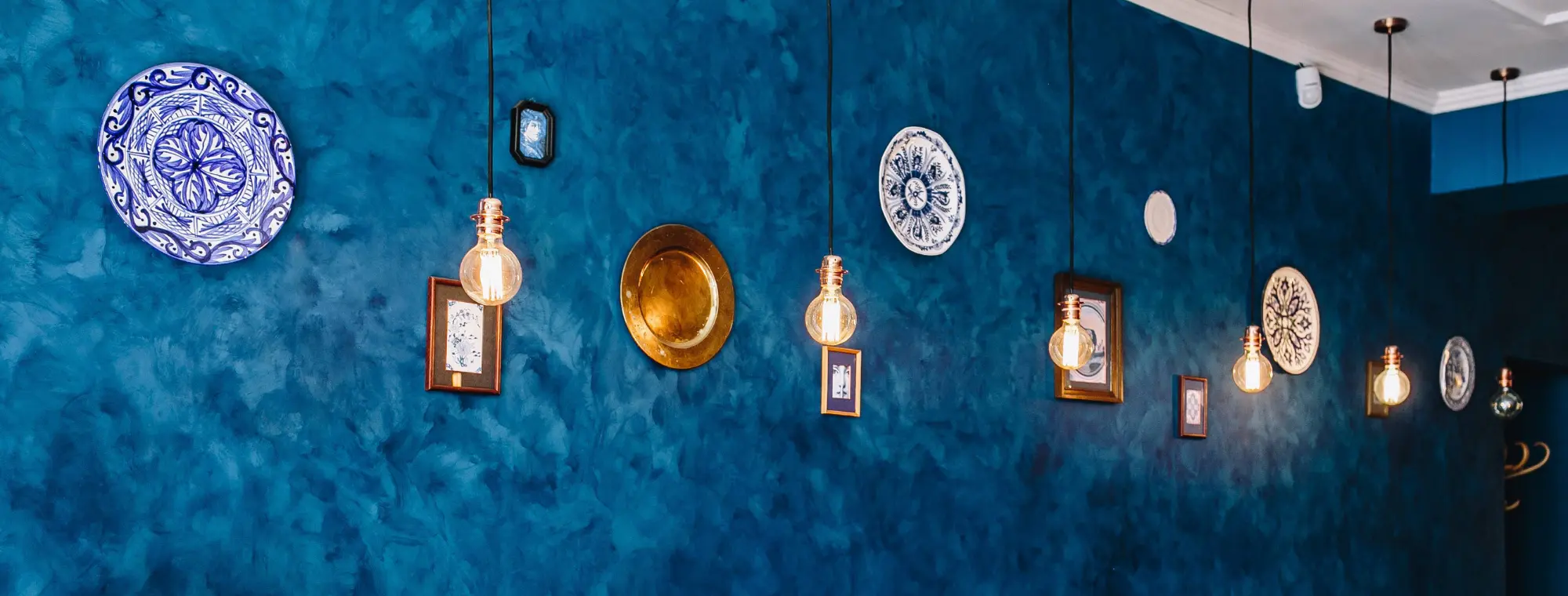 pared azul de un restaurante con platos colgando