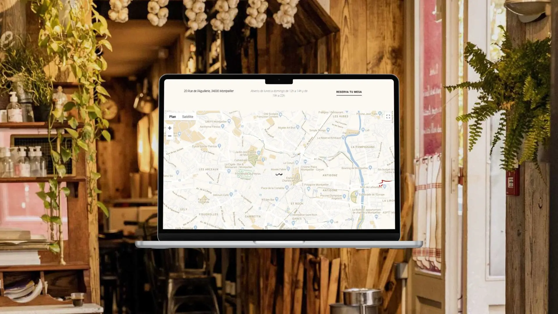 Ordenador portátil con Google Maps abierto para reservar una mesa online sobre fondo de restaurante