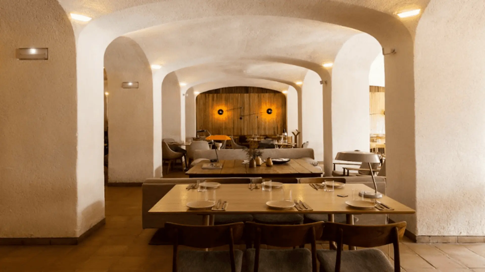 Interior de un restaurante, luces cálidas, mesas y sillas de madera