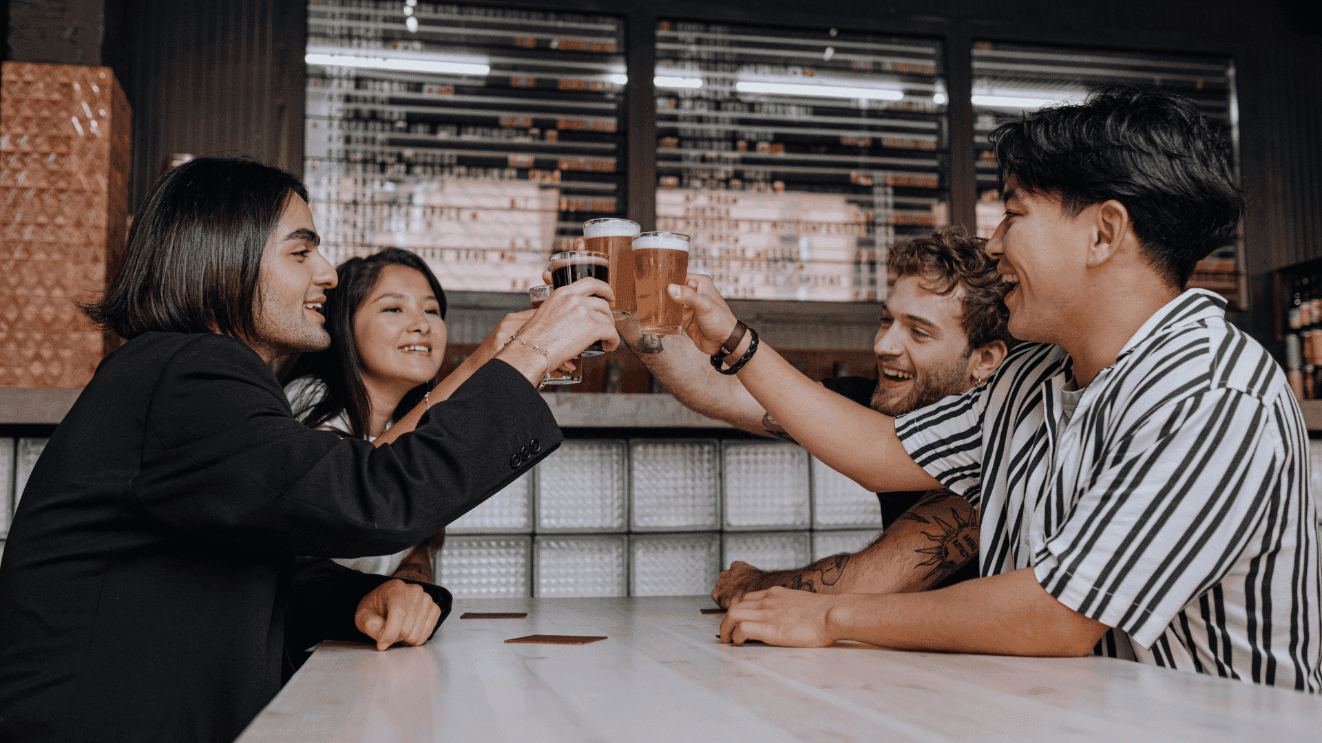 Un grupo de jóvenes adultos brindando con cerveza en un bar