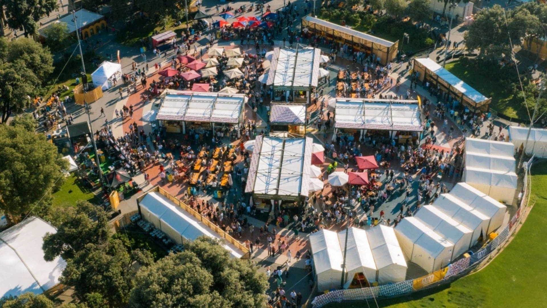 Carpas en una plaza con gente, muestras de comida